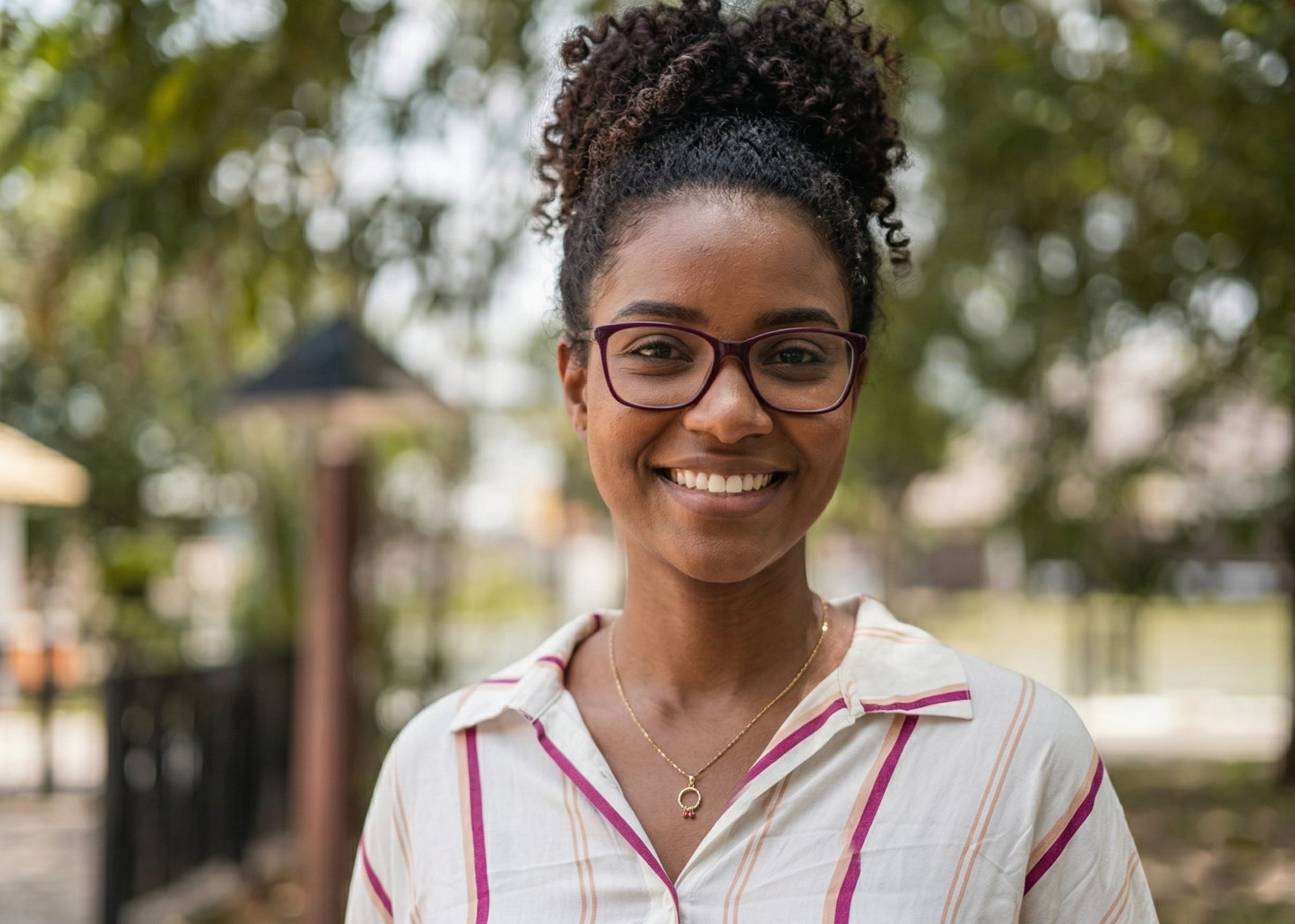 A professional young woman with glasses and a bun hairstyle smiling outdoors. She represents the demographic of iFORWAY 300W power station users, including digital nomads and students who need reliable power for remote work and study.